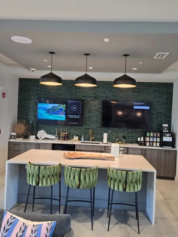Kitchenette with pendant lights and wall-mounted TVs