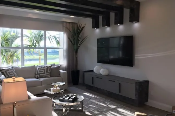 Living room with a wall-mounted TV and recessed ceiling lighting